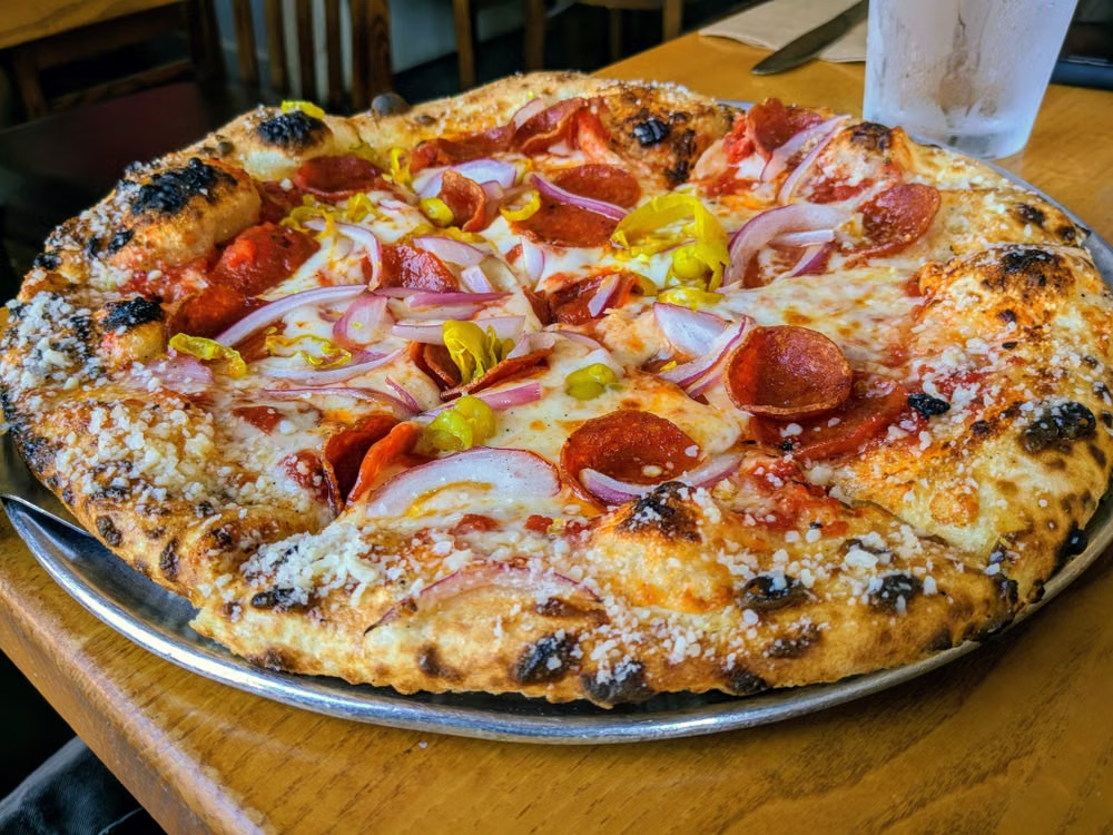 This photo shows a pizza with pepperoni and onions.