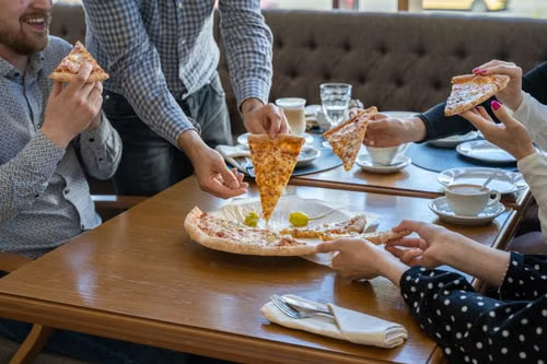 A group enjoys pizza at a neighborhood joint.