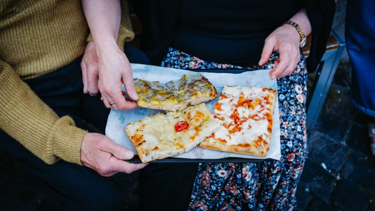 Two people share pizza slices.