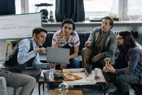 Diverse group of young friends and coworkers enjoying pizza together