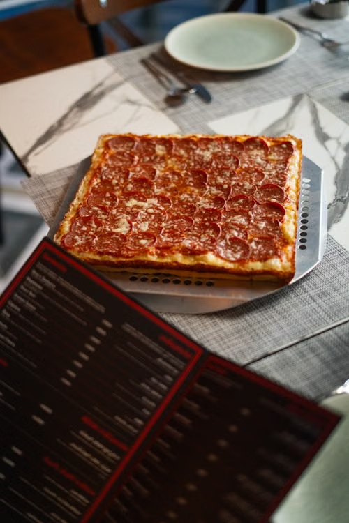 Square-cut pepperoni tavern-style pizza served on a table