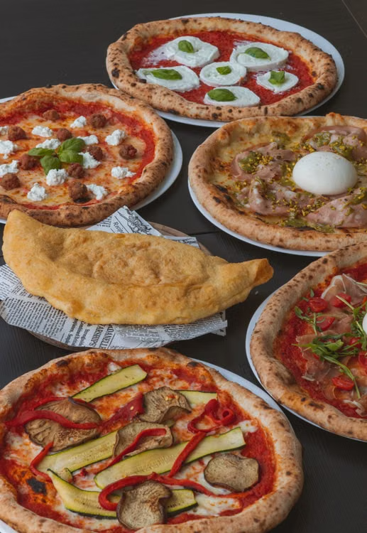 bunch of pizzas with a panzerotti in the center