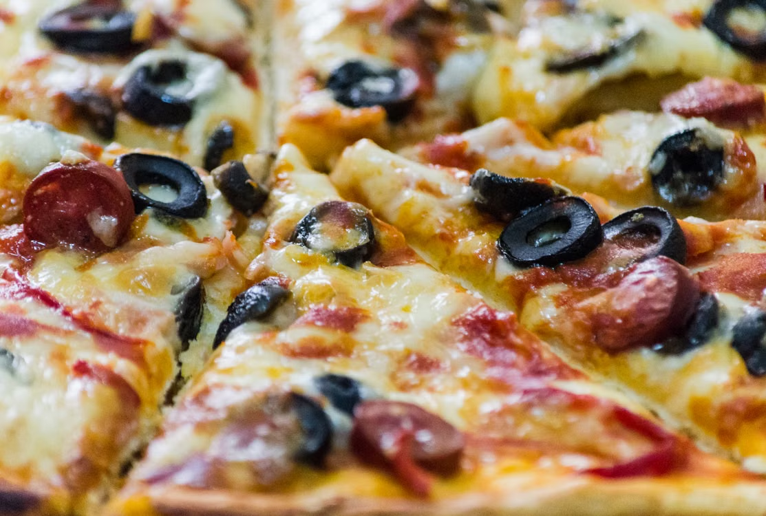 This photo shows a pizza with olives.